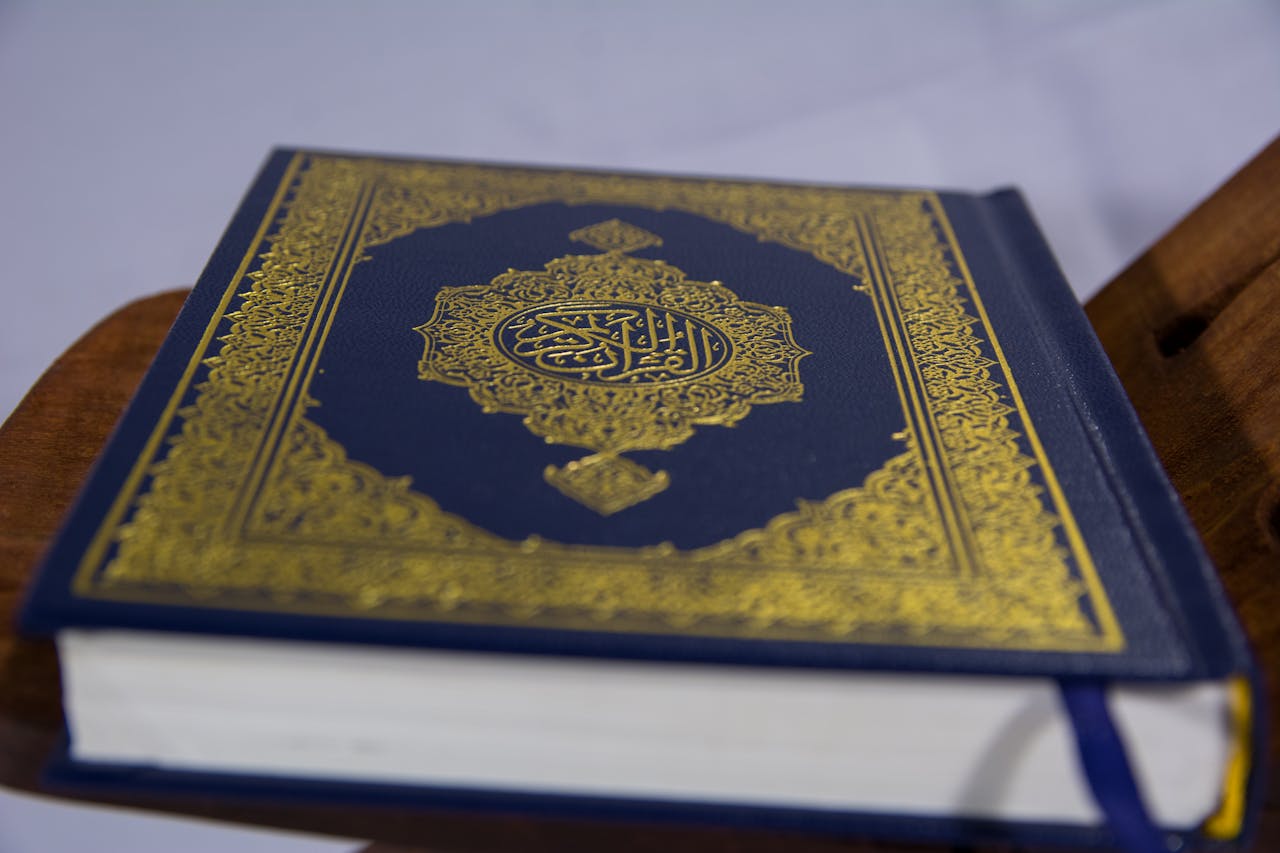 Services Close-up of Quran on stand, showcasing intricate Arabic calligraphy design.